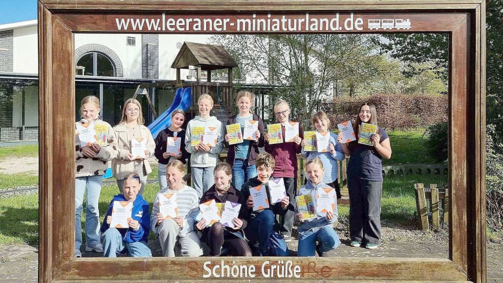 Teilnehmerinnen und Teilnehmer des Vorlese-Kreisentscheids präsentierten sich nach dem Wettbewerb im Leeraner Miniaturland für ein Foto mit den Siegern Amelie Brickwedde und Jared Nowak (vorne, 3. und 4. von links, mit zwei Urkunden). Foto: Käthe Dübbel