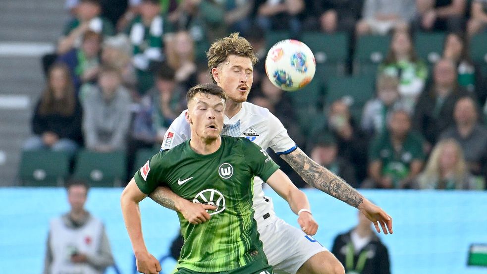 Calvin Brackelmann vom SC Paderborn und der Wolfsburger Dzenan Pejcinovic (vorne) im Zweikampf. Foto: Swen Pförtner/dpa
