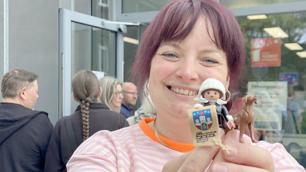 Annika Bischof mit der Fräulein-Maria-Figur vor der Tourist-Info in Jever. Hinter ihr stehen die Leute Schlange für eine der Figuren. Foto: Imke Oltmanns