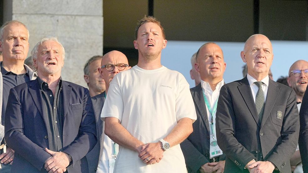 Julian Nagelsmann (m.) steht zwischen DFB-Sportdirektor Rudi Völler (l.) und Verbandschef Bernd Neuendorf (r.) auf der Tribüne des Berliner Olympiastadions. Foto: Michael Kappeler/dpa