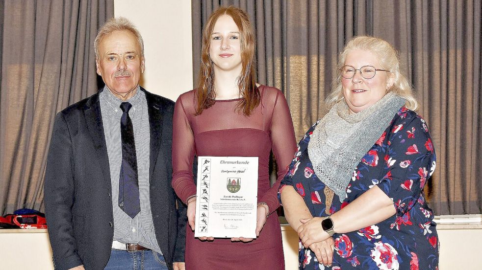 Zarah Podlagar (Mitte) vom Schwimmverein Hesel wurde von Trainerin Britta Oelrichs und Bürgermeister Uwe Themann geehrt. Sie war unter anderem bei den norddeutschen Jahrgangsmeisterschaften erfolgreich. Foto: Melchert Stromann