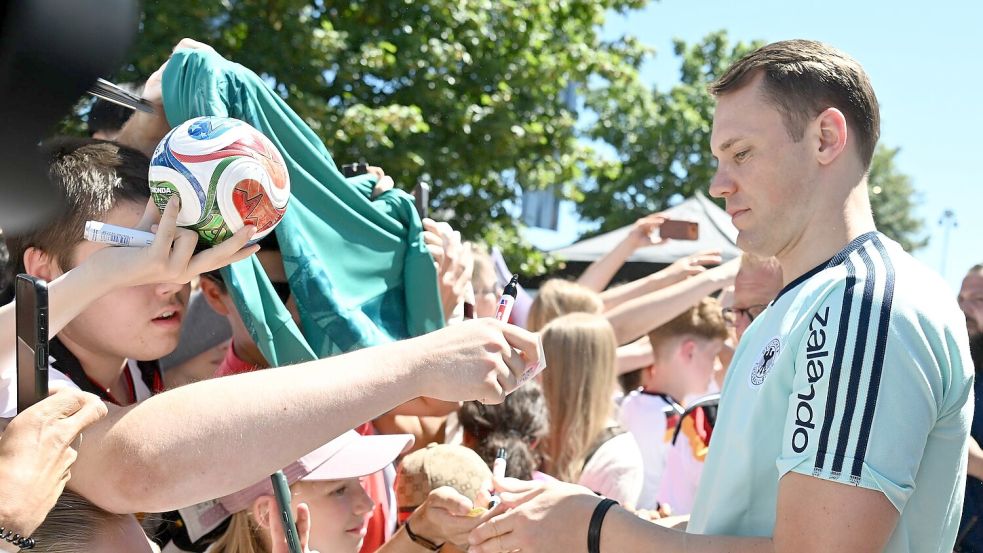 Manuel Neuer schreibt Autogramme. Foto: Federico Gambarini/dpa