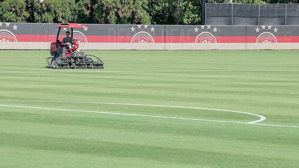 Auf dem Trainingsplatz der DFB-Elf wird der Rasen gemäht. Foto: Jan Woitas