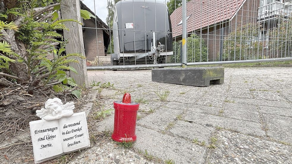 Vor dem Haus stehen die ersten Trauerbekundungen. Foto: Lasse Paulsen