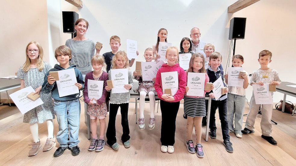 Siegerin beim Vorlesewettbewerb der zweiten Grundschulklassen ist Jule Swart (Mitte, auf dem Tisch sitzend). Mit ihr freuen sich die anderen Teilnehmer sowie Organisatorin Ute Heidergott (links) und Stadtbibliotheks-Leiter Bernhard Bökenkamp (rechts). Foto: Käthe Dübbel