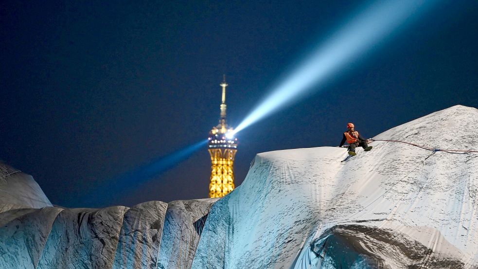 Techniker arbeiten auf der begehbaren Installation "La Caverne du Pont Neuf" (Die Höhle des Pont Neuf) des Künstlers JR, das durch starke Windböen beschädigt worden war. Foto: Christophe DELATTRE / AFP