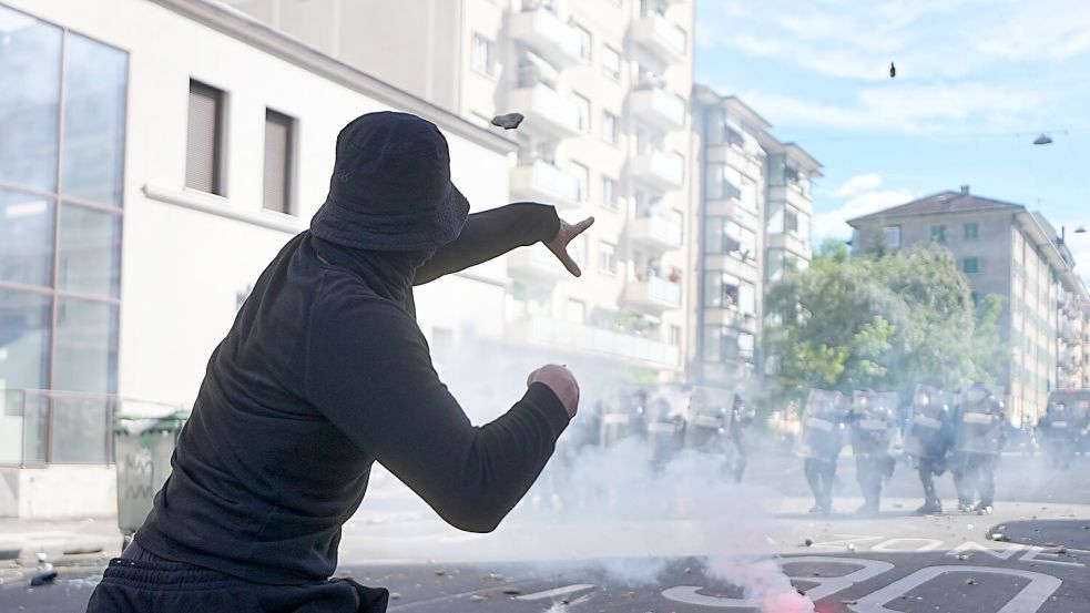 In Genf kommt es bei Protesten gegen den G7-Gipfel in Évian zu Auseinandersetzungen zwischen Demonstranten und der Polizei. Foto: Michael Kappeler/dpa