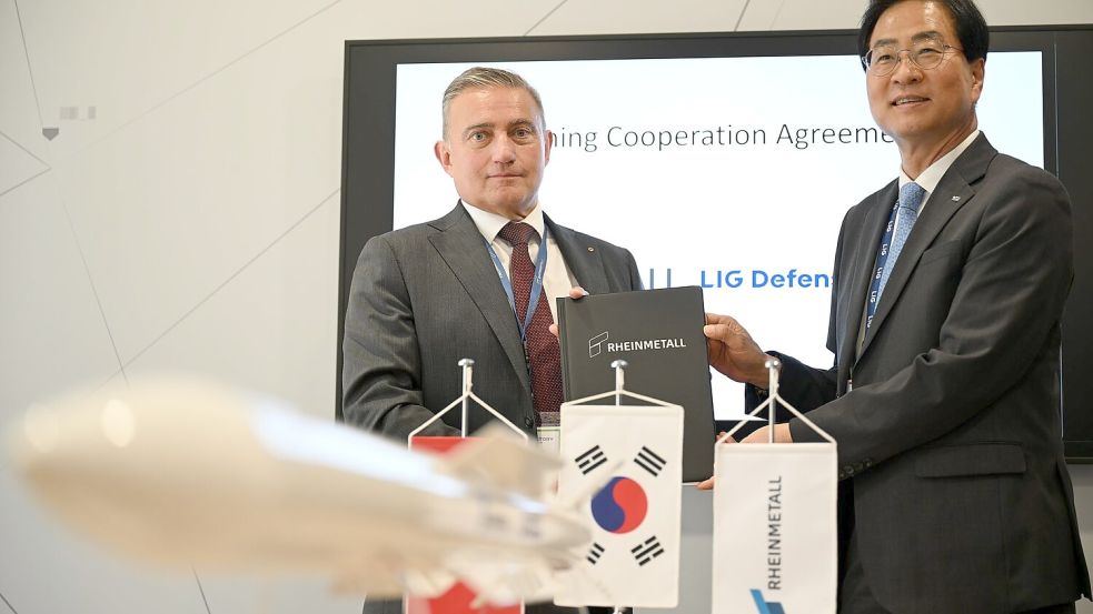 Rheinmetall-Manager Oliver Dürr und der südkoreanische Manager Ickhyun Shin nach der Unterschrift der Vereinbarung bei der Eurosatory. Foto: Wolf von Dewitz/dpa