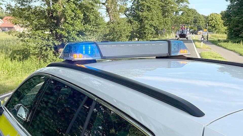 Die Polizei hat die Langholter Straße in Ostrhauderfehn gesperrt. Zwischenzeitlich ist ein Rettungshubschrauber (im Hintergrund) gelandet. Foto: Horst Kruse