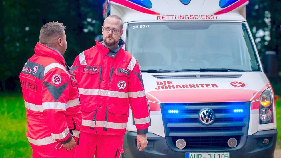 Die Rettungskräfte Niklas Stolze (links) und Daniel Hagen vor dem Wiesmoorer Notfalltransportwagen. Sie begleiteten die Kolonnenfahrt zur Feier der Neuanschaffung. Foto: Laura Hagen
