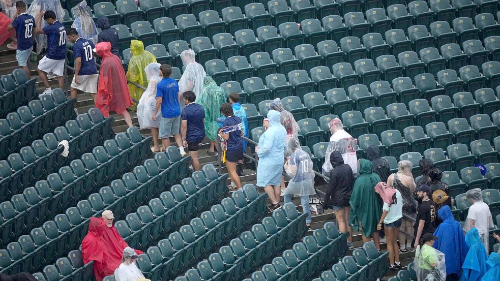 Unwetterwarnung: Fans verlassen die Ränge. Foto: Matt Rourke