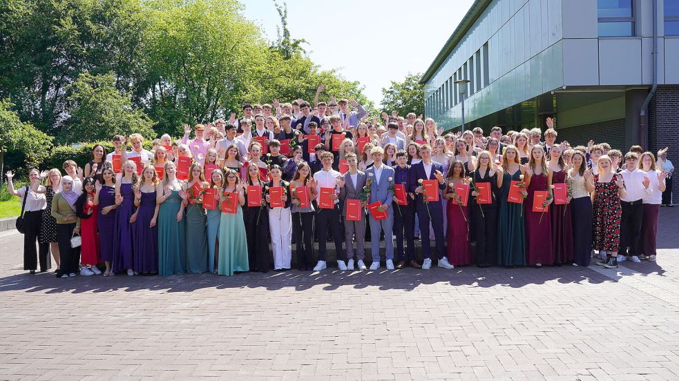 Die Schülerinnen und Schüler feiern fröhlich das Ende ihrer Zeit an der KGS Großefehn. Dabei halten sie ihre Zeugnisse und Blumen in den Händen. Foto: KGS Großefehn