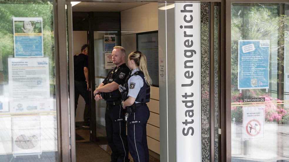 Einsatzkräfte stehen am Eingang des Rathauses. Foto: David Ebener