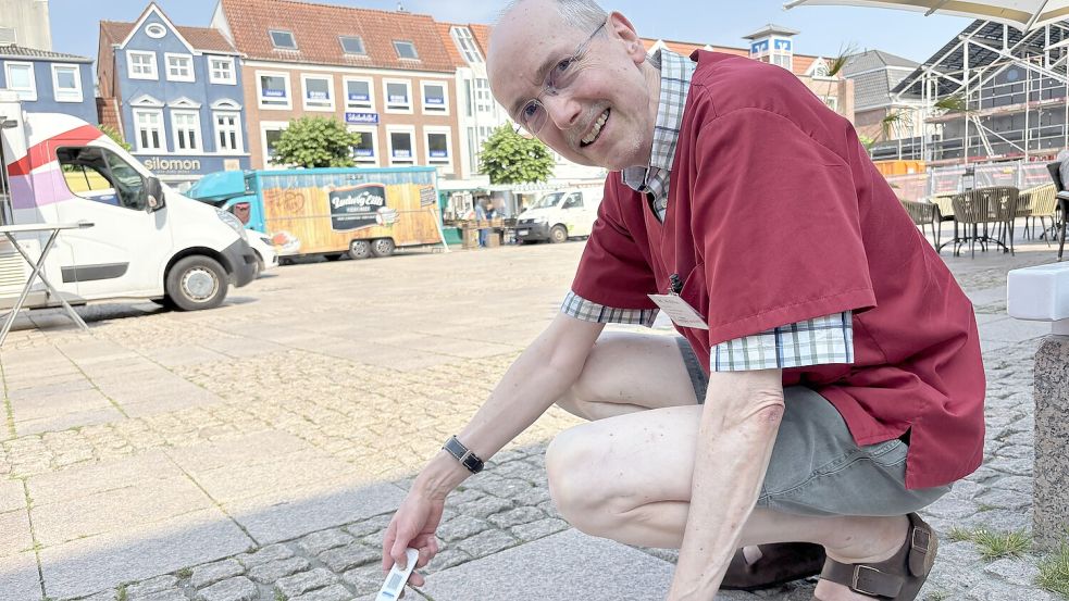 Apotheker Wolfgang Waßmus misst die Temperaturen des Kopfsteinpflasters auf dem Auricher Marktplatz. Foto: Mieke Matthes