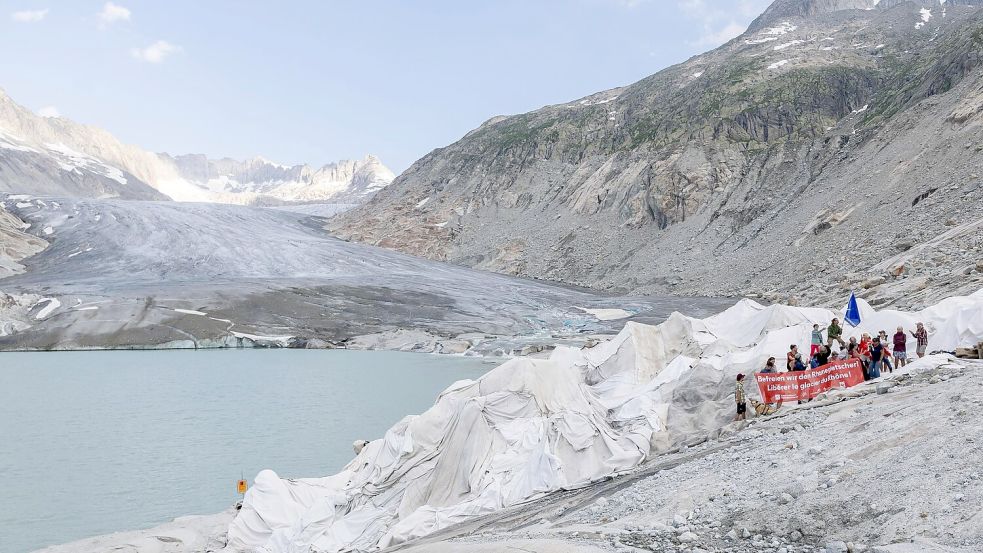 Vertreter von Umweltorganisationen nehmen an einer Aktion teil, bei der der Walliser Regierung symbolisch die Petition „Befreit und schützt den Rhonegletscher!“ überreicht wird. Foto: Cyril Zingaro/KEYSTONE/dpa