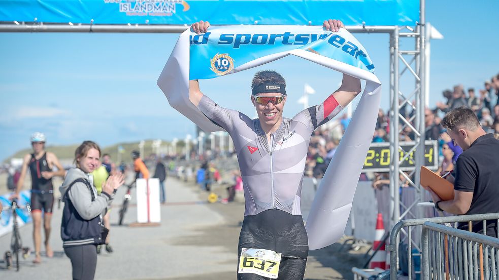Zieleinlauf beim ISLANDMAN auf Norderney: Ein Athlet überquert nach dem abschließenden Lauf die Ziellinie. Foto: Neil Baynes