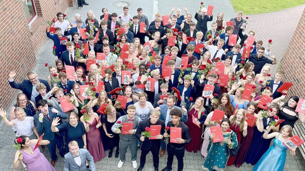 Die Schülerinnen und Schüler präsentieren fröhlich und in feinem Zwirn ihre Abschlusszeugnisse. Foto: IGS Ihlow