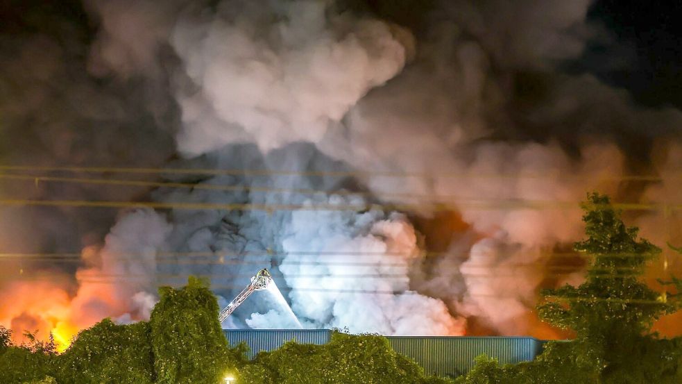 Einsatzkräfte der Feuerwehr bekämpfen den Brand in einem Gewerbegebiet in Stuttgart. Foto: Christoph Schmidt