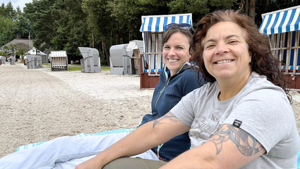 Marie Rabenstein und Pia Heuer aus Holtland genießen die Ruhe am Ottermeer bei grauem Himmel. Ab dem 10. Juli 2026 soll es wieder freundlicher werden. Wer Ruhe mag, sollte die letzten Tage der Sommerpause nutzen – wie die beiden. Foto: Nicole Böning