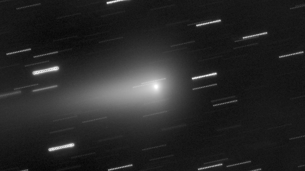 In der Mitte ist der Komet 3I/Atlas zu sehen. Die Sterne im Hintergrund erscheinen als Lichtspuren, weil die Aufnahme aus mehreren nacheinander aufgenommen Einzelbildern zusammengesetzt wurde. Foto: O. Hainaut/ESO/dpa