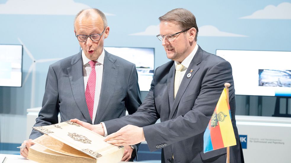 Auch einmal staatstragende Aufgaben: Bei der Maritimen Konferenz präsentiert Oberbürgermeister Tim Kruithoff (parteilos) Bundeskanzler Friedrich Merz (CDU) das Goldene Buch der Stadt Emden. Foto: Klaus Ortgies/Archiv