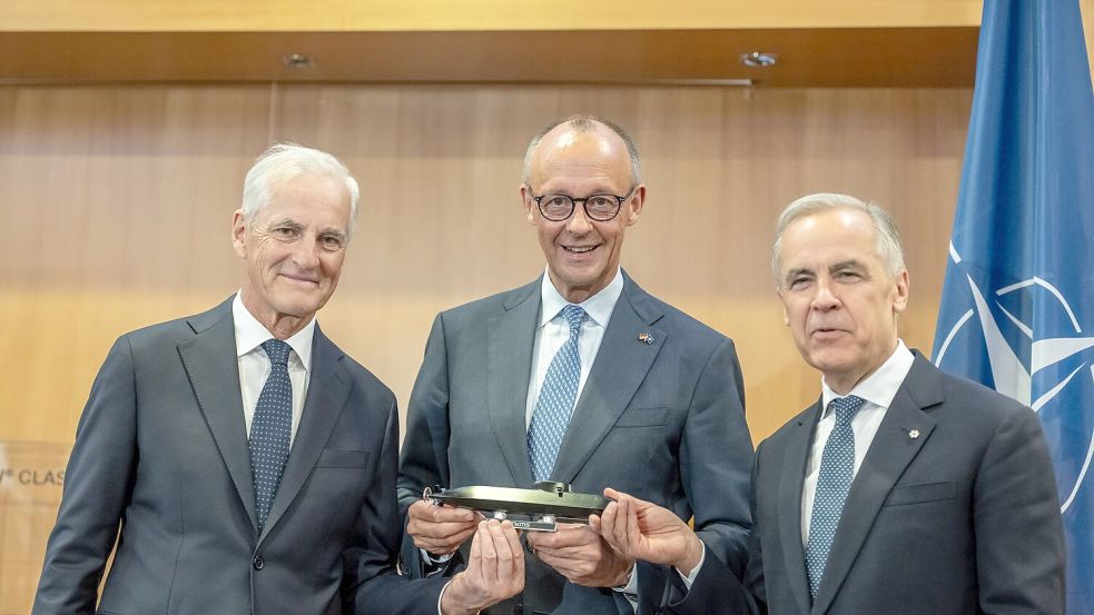 Kanzler Merz freut sich mit Kanadas Premier Mark Carney (l.) und dem Ministerpräsidenten von Norwegen, Jonas Gahr Støre (r.), über den U-Boot-Deal. Foto: Michael Kappeler/dpa-Pool/dpa