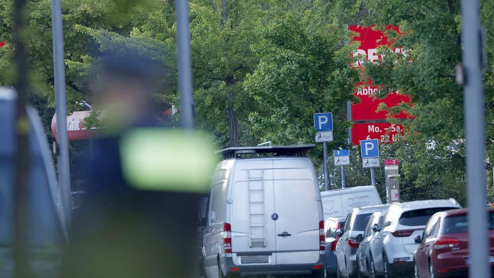 Der Supermarkt ist großräumig abgesperrt. Foto: Carsten Koall/dpa