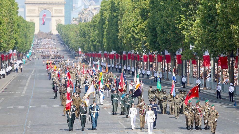 Soldaten aus Partnerstaaten der Koalition der Willigen haben die Militärparade zum französischen Nationalfeiertag in Paris angeführt. Foto: Ludovic Marin/AFP/dpa