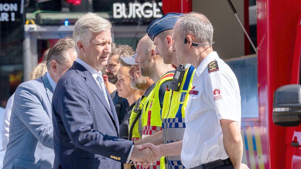 Der belgische König Philippe (vorne) und Ministerpräsident Bart De Wever bedanken sich bei Rettungskräften. Foto: Marius Burgelman