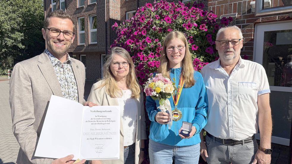 Silbermünze und Urkunde verliehen Bürgermeister Sven Lübbers (links) und seine beiden stellvertretenden Bürgermeister Gabriele Münch (2.v.l.) und Friedhelm Jelken an Fenna Behrends. Foto: Verena David/Stadt Wiesmoor
