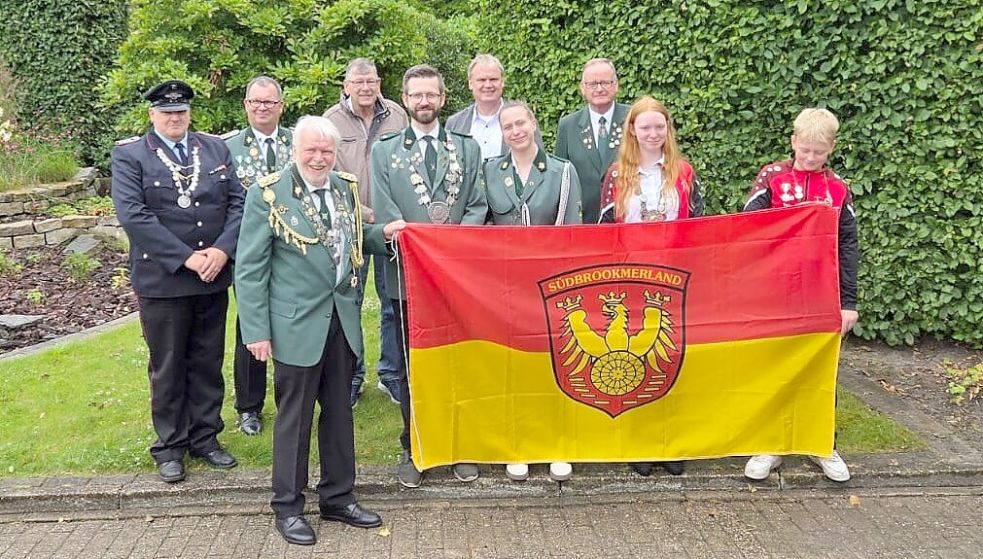 Die Georgsheiler Gemeindeflagge präsentieren (hintere Reihe, von links): Feuerwehrkönig Ralf Harms, stellvertretender Vorsitzender Uwe Menssen, Ortvorsteher Gerold Meyer, Bürgermeister Thomas Erdwiens und Detlef Temmen, Präsident des Ostfriesischen Schützenbunds, sowie (vorne, von links): Schützen-Vorsitzender und Kronprinz Gerhold Heinze, Schützenkönig Heiko Rector, Adjutantin Pia Wendeling, Jugendkönigin Wera Ihnen und Schülerkönig Heiko Ihnen. Foto: privat
