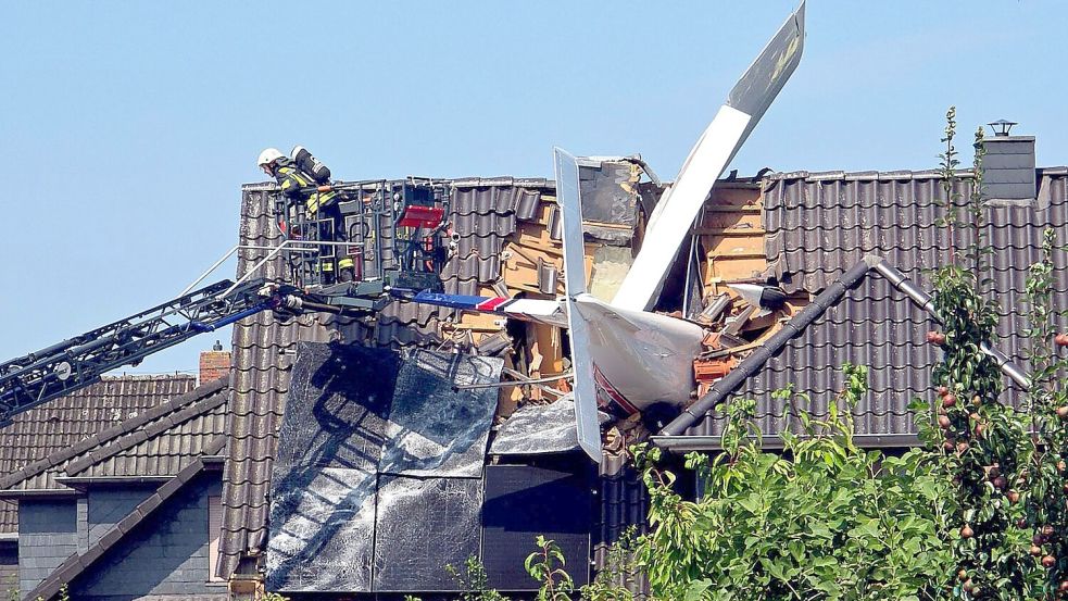 Das Leichtflugzeug stürzte in der Wohnsiedlung in das Dach. Foto: Fotoreport-DB/NWM-TV/dpa