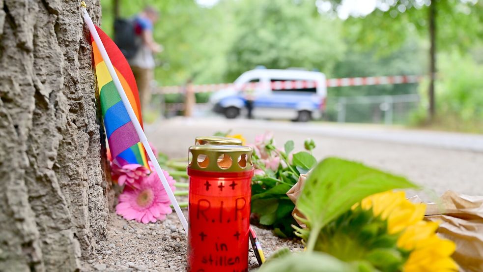Am Rande des Christopher Street Day in Berlin war das Fahrzeug in eine Menschenmenge gefahren. Dabei wurde eine Frau getötet, 16 weitere Menschen verletzt, zum Teil schwer. Am Tag nach der Tat stehen eine Regenbogenflagge, Blumen und Kerzen nahe des Tatorts. DPA-Foto: Sebastian Gollnow