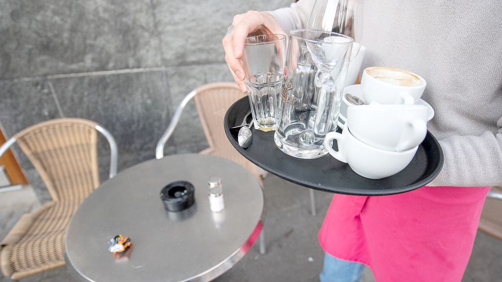 Ein Kellner räumt einen Tisch in einem Restaurant ab. Foto: Sebastian Gollnow