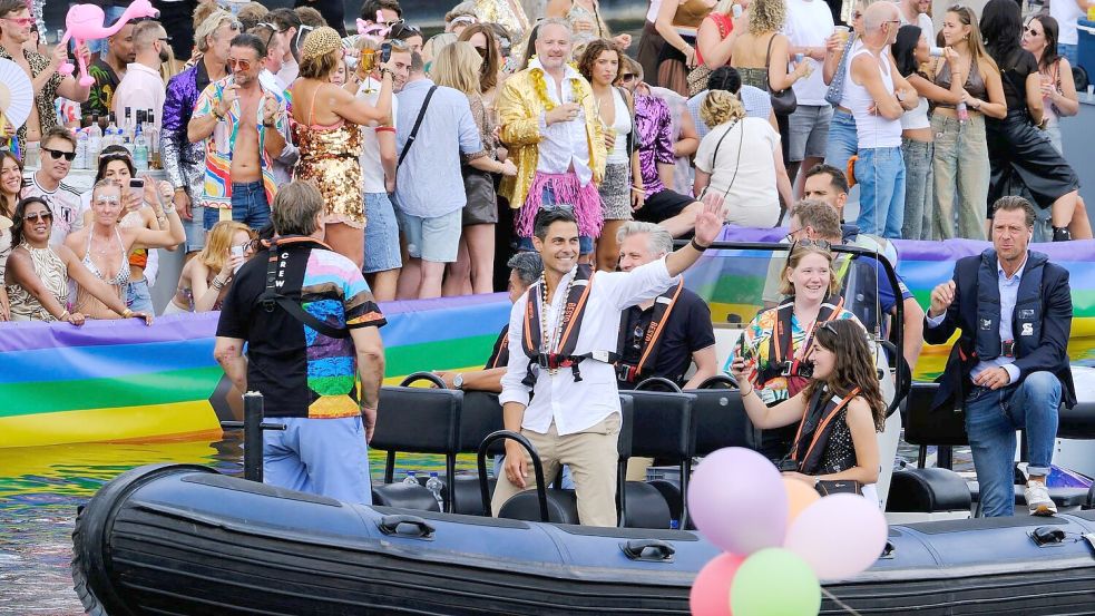 Der niederländische Ministerpräsident Rob Jetten steht auf einem Boot und winkt während der Canal Parade in Amsterdam. Foto: Patrick Post