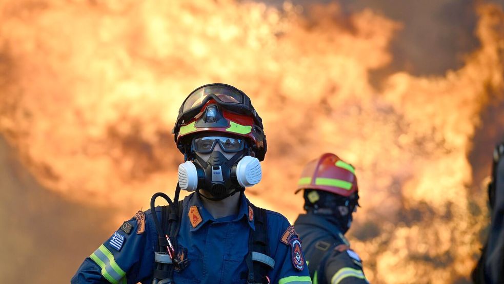 Ein Feuerwehrmann steht vor den lodernden Flammen nordwestlich von Athen. Foto: Michael Varaklas