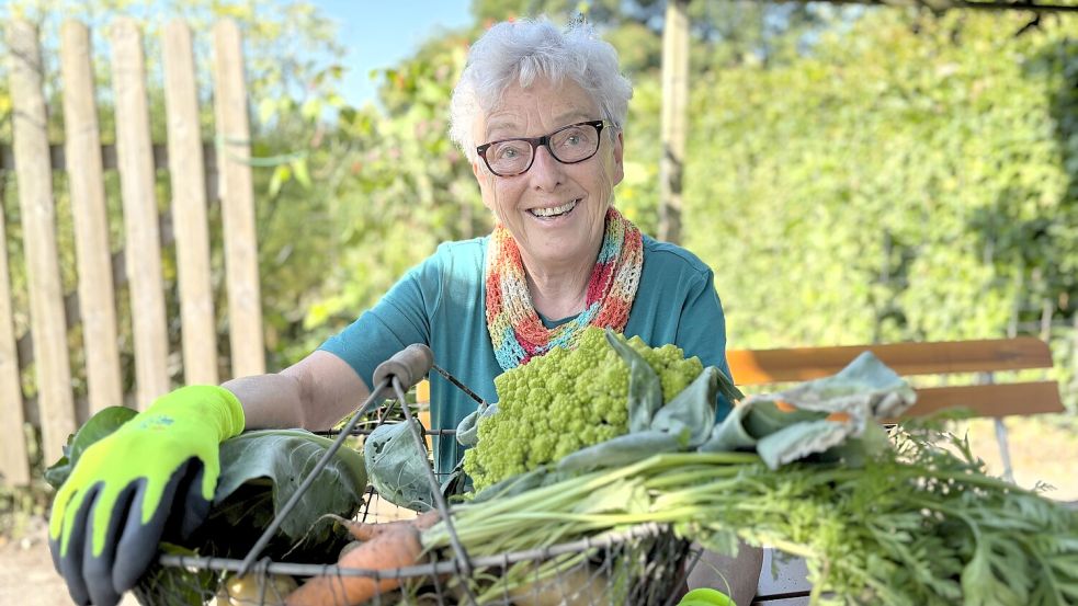 Martha Gerdes mit frischer Ernte aus dem Bauerngarten im Torf- und Siedlungsmuseum Wiesmoor: Möhren, Kartoffeln, Romanesco und Spitzkohl. Foto: Nicole Böning