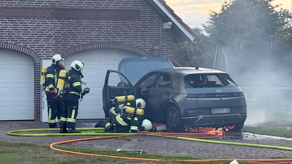 Das brennende Elektrofahrzeug war in unmittelbarer Nähe einer Garage abgestellt. Atemschutzgeräteträger bekämpften das Feuer von zwei Seiten. Foto: Sönke Geiken, Stadtfeuerwehr Aurich