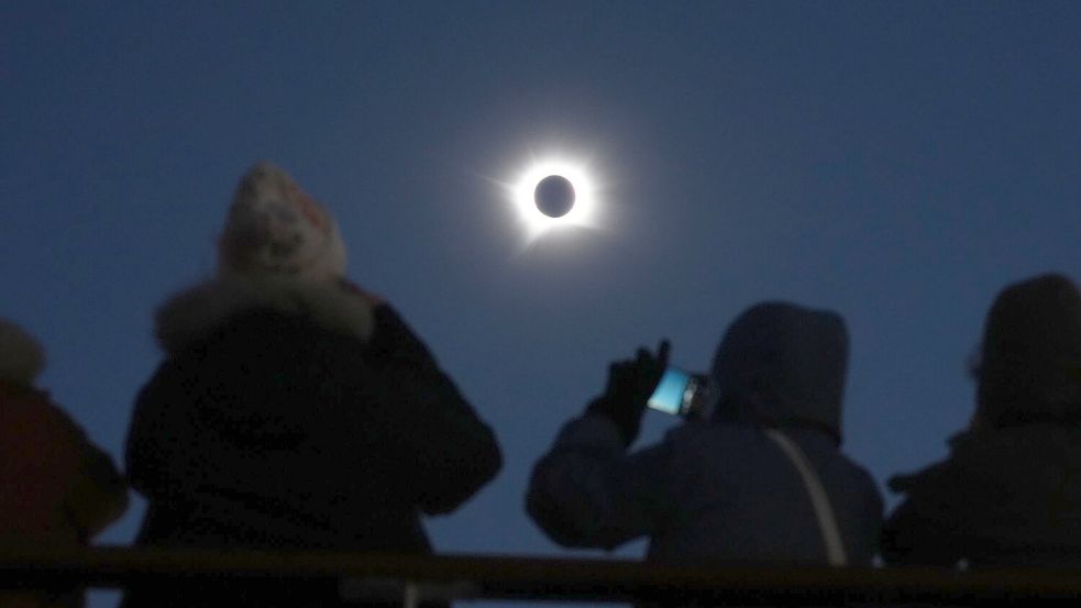 Passagiere schauen auf die totale Sonnenfinsternis an Bord des Kreuzfahrtschiffs „Ambition“ der Reederei Ambassador vor der Küste Grönlands. Foto: Owen Humphreys
