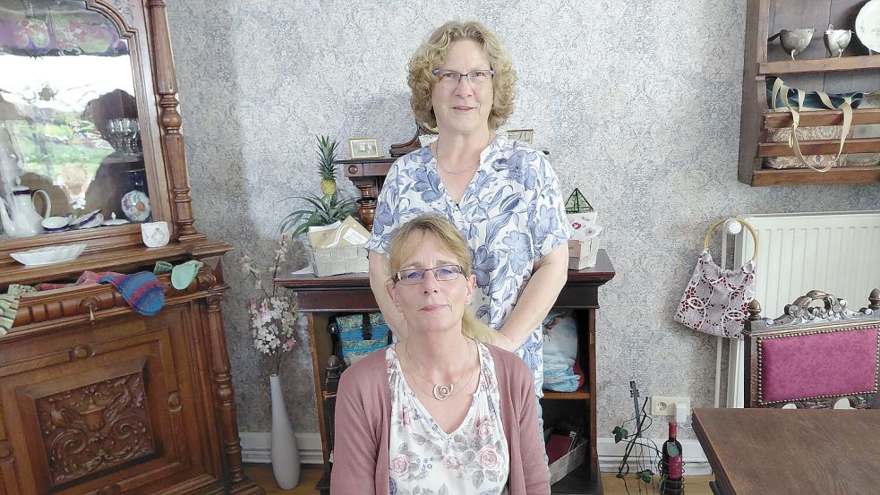 Inhaberin Claudia Rieken (hinten) und Silke Janssen Wolbergs (vorne) in ihrem Antik-Café „Lüttje Stuuv an’t Kark“ in Suurhusen. Foto: Lisa Siegler
