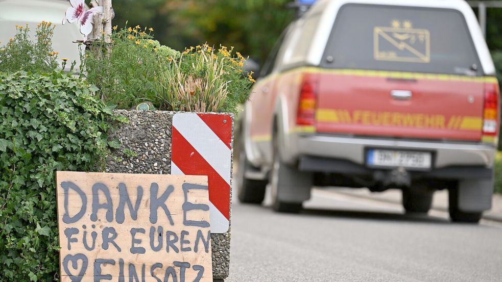 Ein Fahrzeug der Feuerwehr fährt an einem Schild mit der Aufschrift „Danke für Euren Einsatz“ beim Waldbrand im Hürtgenwald vorbei. Foto: Federico Gambarini/dpa