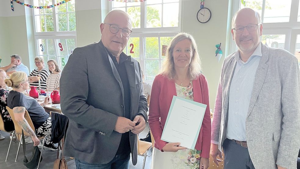 Thomas Eule (recht) vom Regionalen Landesamt für Schule und Bildung und Jemgums Bürgermeister Hans-Peter Heikens gratulieren Frauke Tillmann. Foto: privat