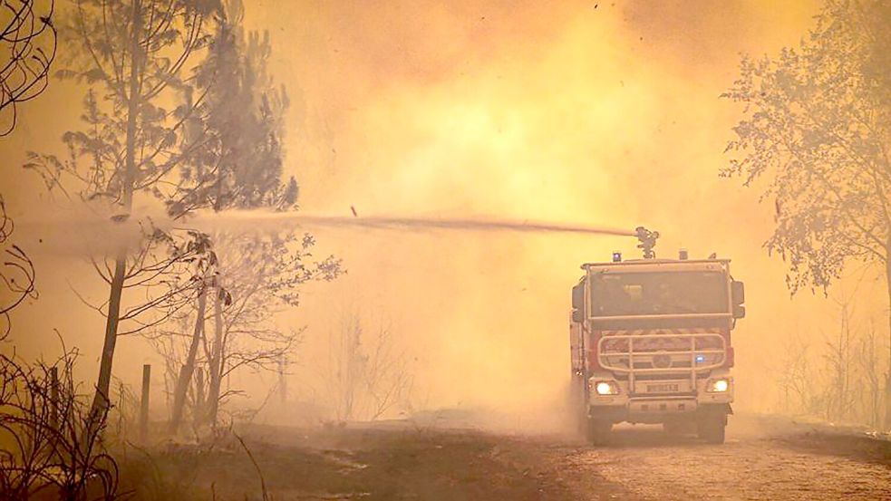 Ein Feuerwehrwagen sprüht Flüssigkeit auf einen Waldbrand in der Region Bordeaux. (Archivbild) Foto: Uncredited/Service Communication
