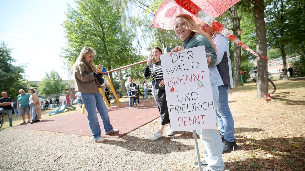 Demonstranten protestierten unter anderem mit einem Plakat, auf dem „Der Wald brennt und Friedrich pennt“ stand. Foto: Christoph Reichwein/dpa