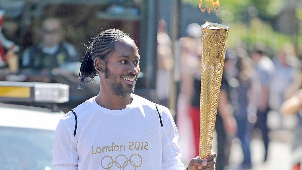 So vorbildlich wollte er erscheinen: Jason Arday trägt die olympische Fackel auf der Etappe des Fackellaufs zwischen Sutton (Londoner Stadtbezirk) und Merton (Londoner Stadtbezirk). Foto: Joe Giddens/PA Wire/dpa