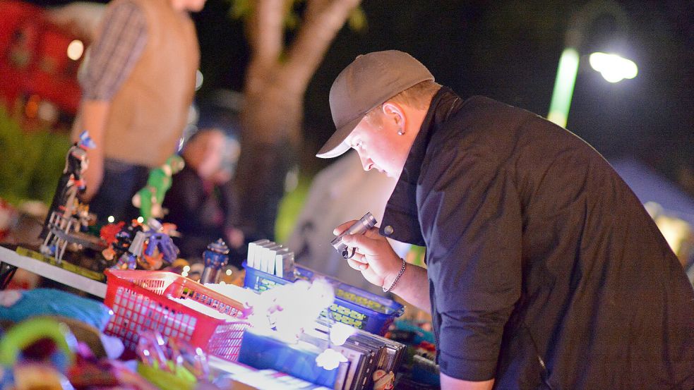 Im Schein der Taschenlampe an Flohmarktständen nach Schätzen stöbern: Das kann man am Sonnabend in Simonswolde. Foto: Klaus Ortgies/Archiv