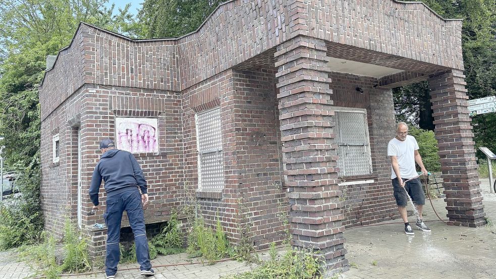 Mit Wasserschlauch und Lösungsmittel gegen Graffiti: Dennis van Dyken (links) und Wolfgang Janßen von der städtischen Gebäudereinigung waren hier zuletzt am Werk. Foto: Stephanie Schuurman/Archiv