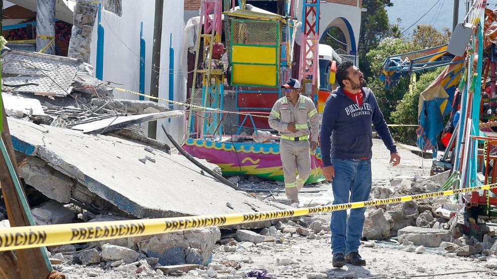 Feuerwehrleute untersuchten das durch eine Feuerwerksexplosion zerstörte Gebiet. Foto: Ramses Mercado