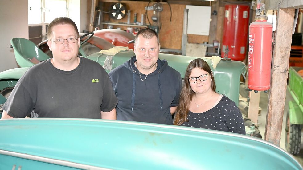 Die Oldtimerfreunde Krummhörn pflegen ihre historischen Trecker mit viel Herzblut. Malte Weets, Christian Fokken und Kerstin Fokken (von links) treffen sich gemeinsam mit den anderen Vereinsmitgliedern regelmäßig zum Schrauben und Klönen. Foto: Heinz Wagenaar