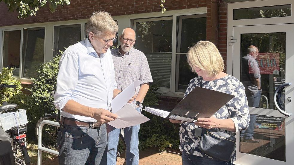 Irene Preyk (von rechts) und Uwe Türbsch von der BI Dorfstraße überreichen Gerd Dählmann eine Unterschriftensammlung zur Abschaffung der Straßenausbaugebühren. Foto: Jasmin Oltmanns